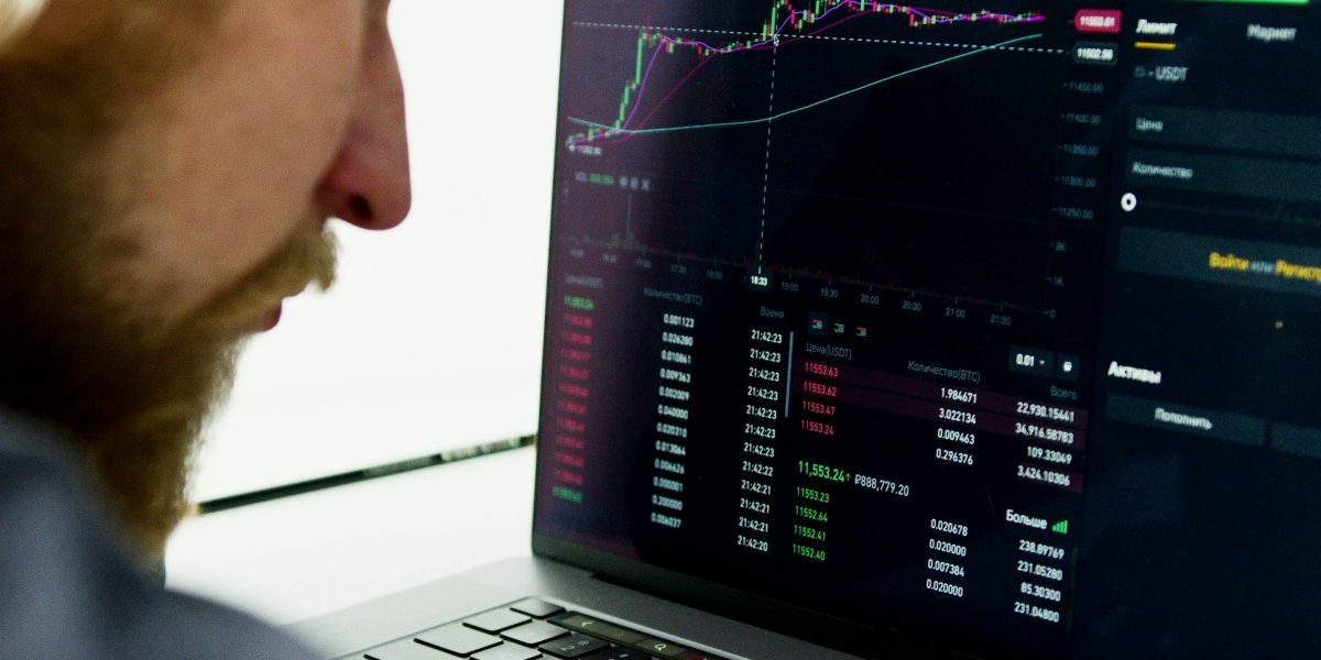 An investor reflects on complex market data, aiming to find clear investment opportunities amidst volatility.
