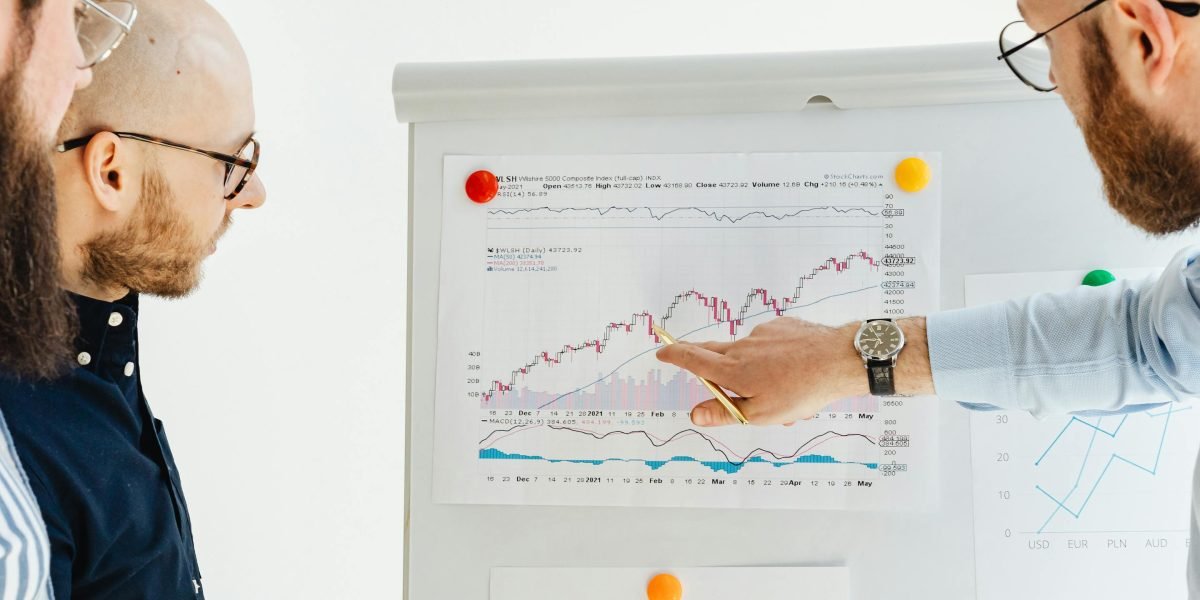 A team collaborating in a meeting, discussing global factors and regulations affecting market trends and investments.