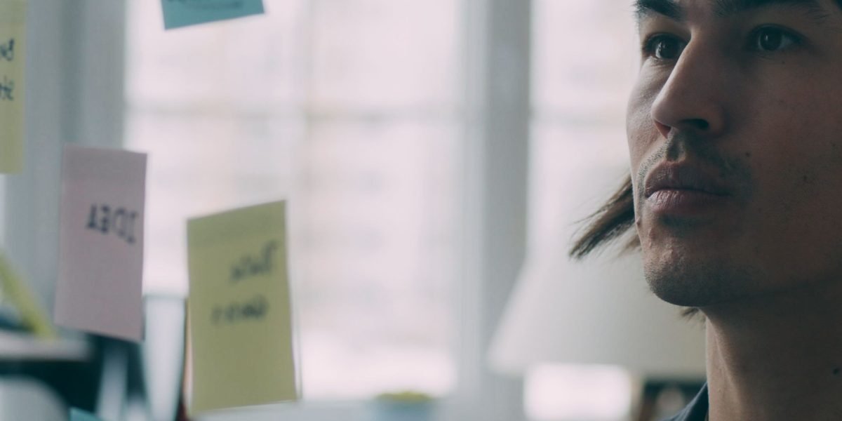 A professional contemplating complex information, symbolizing the challenge of making informed decisions in the rapidly evolving AI landscape.