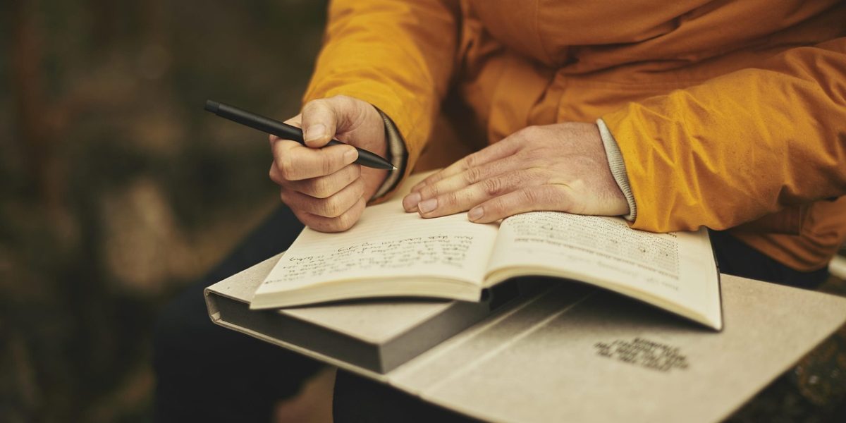 A person carefully reviews documents, symbolizing diligence in checking job postings to avoid scams.