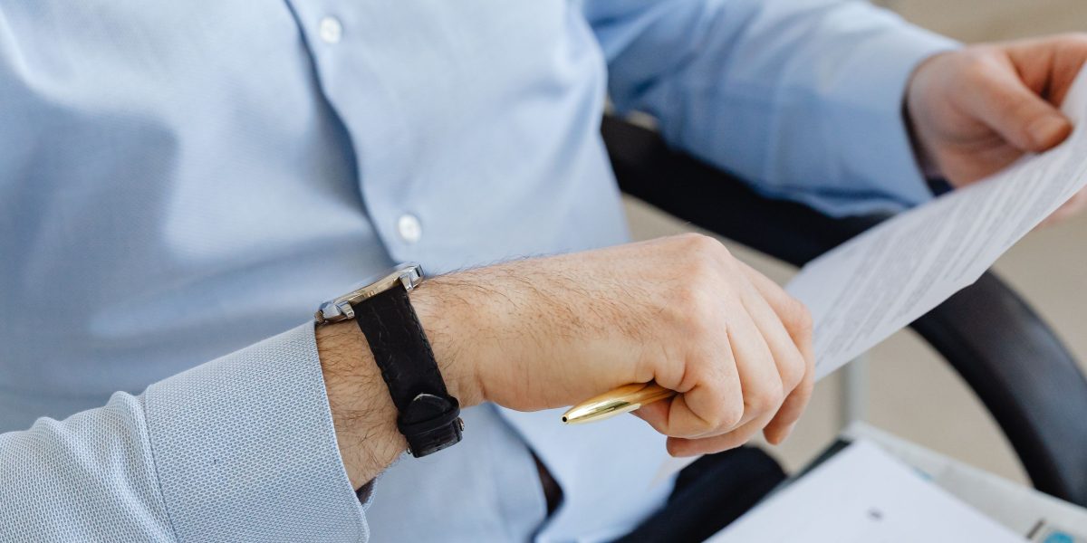 An individual meticulously reviews financial documents, concentrating on details for informed trading decisions.