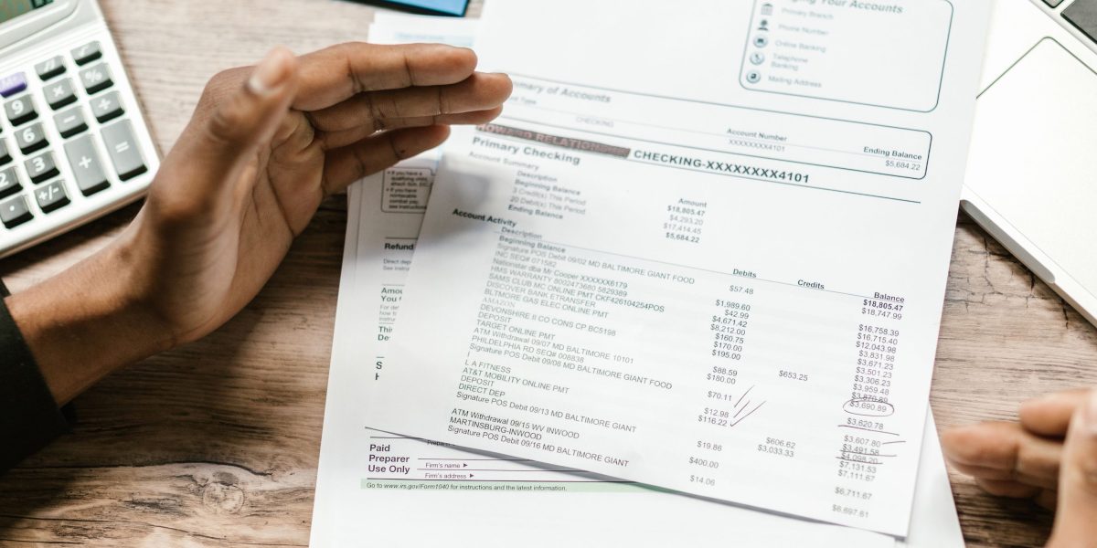 A professional meticulously reviews financial documents, representing the strategic budgeting for remote roles.