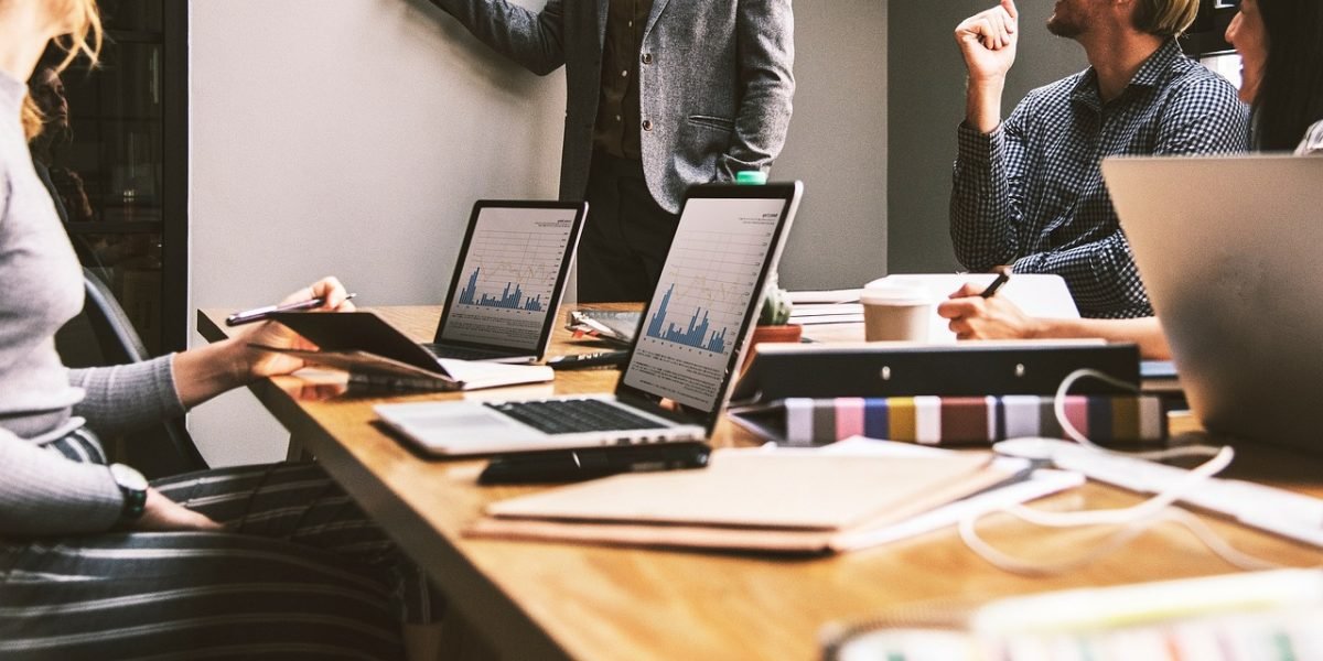 A business team evaluates various AI platforms, weighing their features, costs, and benefits on a whiteboard.