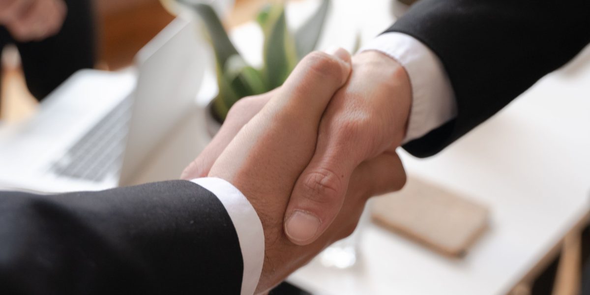 Business partners shaking hands, symbolizing a successful deal or collaboration.