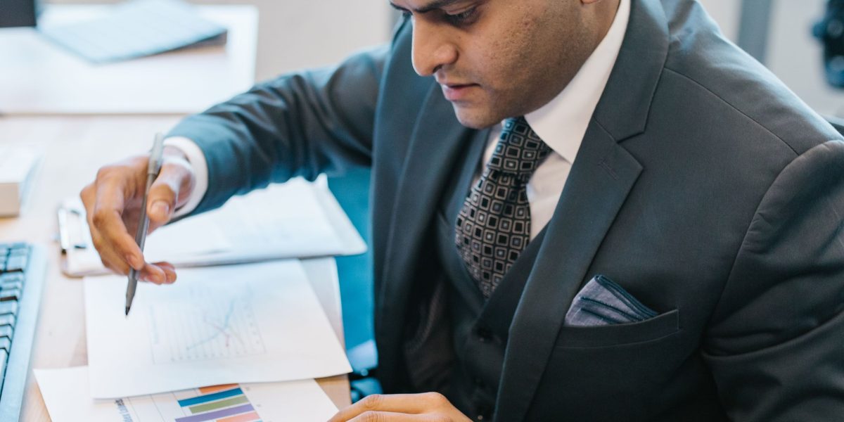 A person intently analyzing business reports, symbolizing the process of measuring ROI and brand lift.