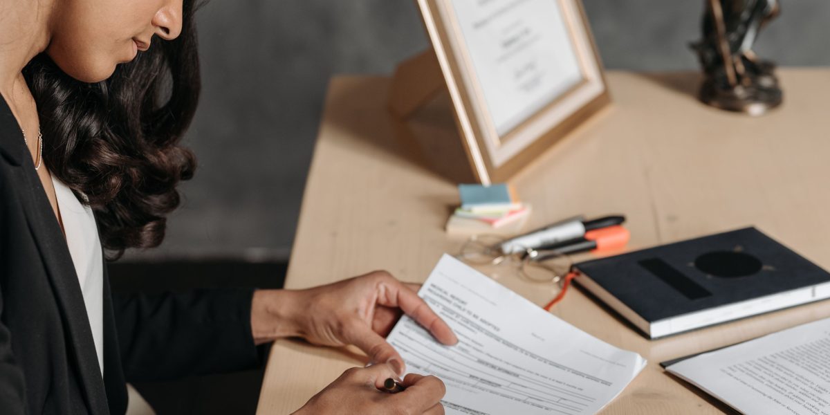 A professional meticulously examining legal documents related to intellectual property and compliance.