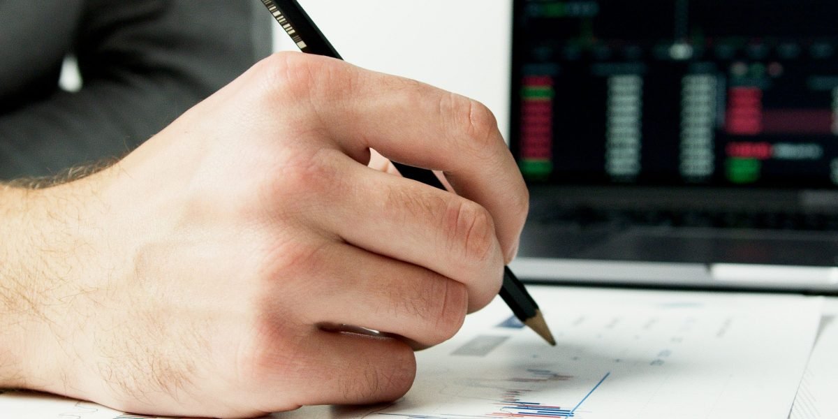 An investor meticulously reviewing market data, seeking critical signals amidst information overload.
