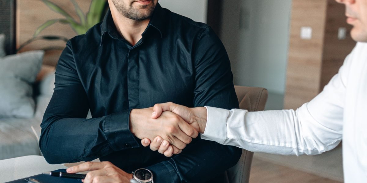 Two professionals sealing a deal with a handshake, symbolizing successful collaboration and investment partnerships in the healthcare AI sector.