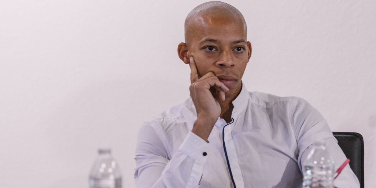 A serious investor carefully listening to a business presentation, reflecting the crucial due diligence phase for potential funding.